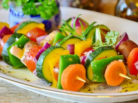 Drei vegane Gemüsespieße liegen auf einem Teller