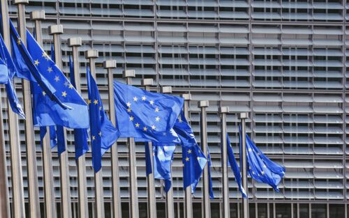 Mehrere Europa-Flaggen vor einem grauen Gebäude