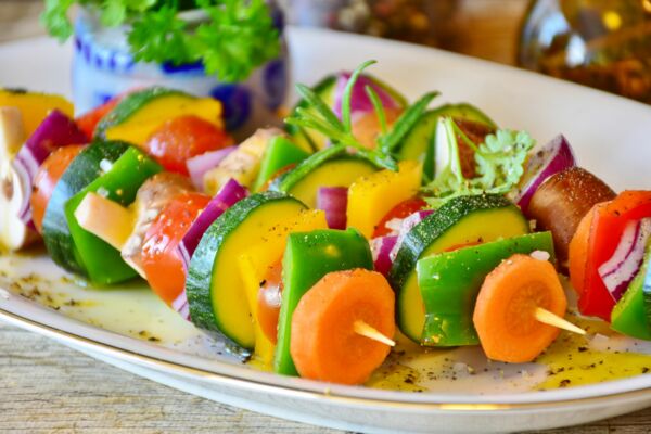 Drei vegane Gemüsespieße liegen auf einem Teller